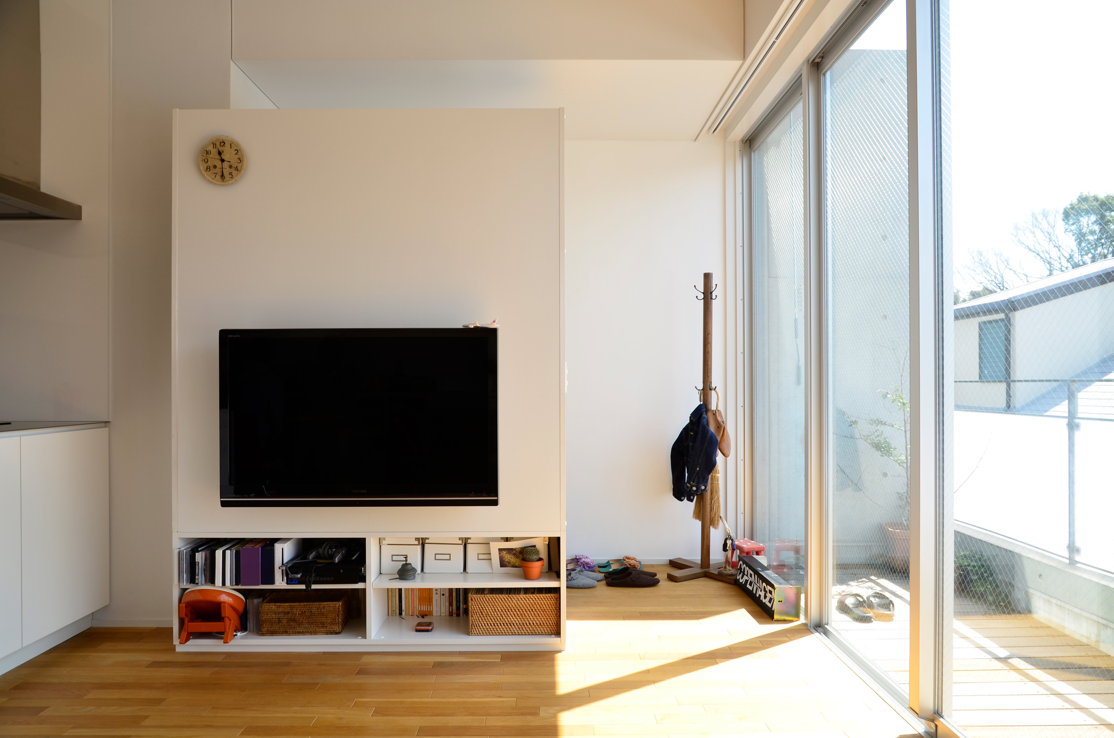 テレビの裏側が玄関。壁を天井まで建てず開放的な空間に