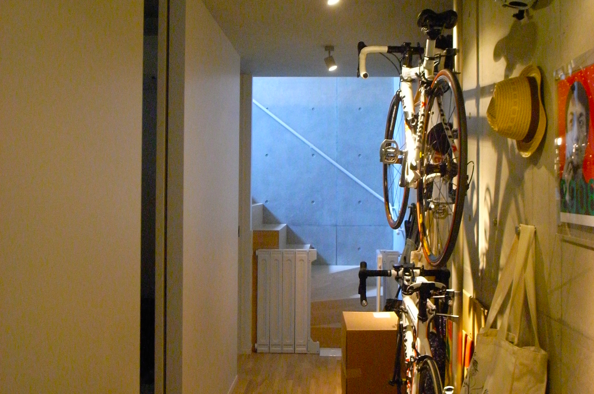 玄関は、自転車の他に、帽子や鞄を壁付のフックにかけて見せる収納