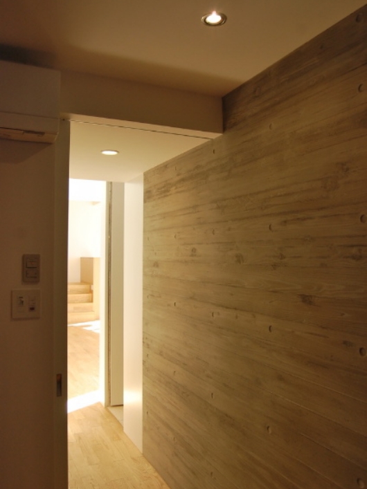 寝室へつながる廊下壁は木目付のコンクリート打ち放しです。